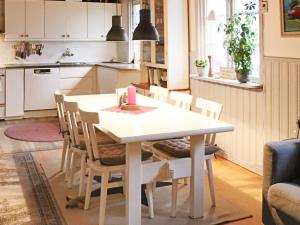 uma cozinha com uma mesa branca e cadeiras em Holiday home LAHOLM X em Laholm