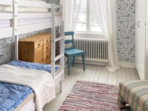 a bedroom with bunk beds and a chair and a window at 4 star holiday home in HJORTKVARN-By Traum in Haddebo