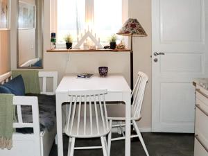 una pequeña cocina con mesa blanca y sillas en Holiday home HALMSTAD X, en Halmstad