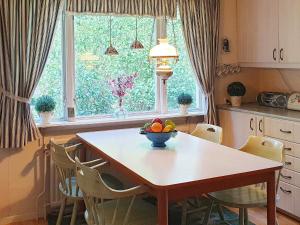 - une cuisine avec une table et un bol de fruits dans l'établissement Holiday home Annerstad, à Skärseryd
