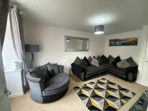a living room with a couch and two chairs at Kingsway House - Brand New Spacious 4 Bed Home From Home in Derby