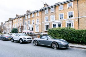 three cars parked on a street in front of a building at Wonderful Two-Bedroom Apartment in London