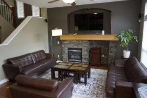 a living room with leather furniture and a fireplace at Metropolitan Dream Stay with Cozy Fireplace and Hot Tub in Surrey
