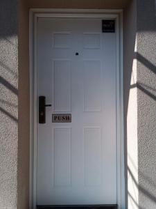 Una porta bianca con un cartello che dice "spingi". di Apartment CENTAR a Šabac