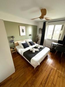 a bedroom with a large bed and a ceiling fan at T3/2 douches/Parking/Villejuif/Paris/IGR in Villejuif