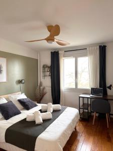 - une chambre avec 2 lits et un ventilateur de plafond dans l'établissement T3/2 douches/Parking/Villejuif/Paris/IGR, à Villejuif