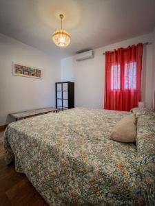 a bedroom with a large bed and a red curtain at Casa rural , campo ocio, eventos, Villa Rural in Dos Hermanas +17 photos