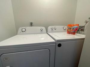 un pequeño lavadero con lavadora y secadora en Cute & Cozy Suite in Overland Park en Overland Park