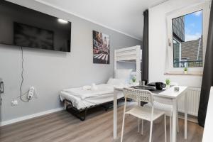 デュースブルクにあるMesse, Monteure, Budget - Einfache komfortable 2 Personen Wohnung (22qm) mit Vollausstattung (WLAN 250 Mbit, TV 55 Zoll m. Netflix) - Hochwertige Küche und Badのベッド、テーブル、椅子が備わる客室です。