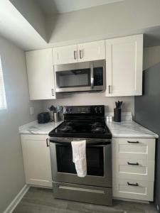 a kitchen with a stove and a microwave at Cute & Cozy Suite in Overland Park in Overland Park