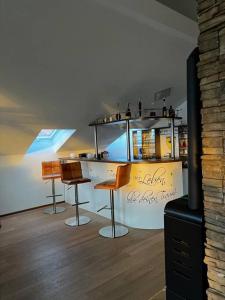 uma cozinha com três bancos de bar e um balcão em Pit-Stop Allgäu em Argenbühl