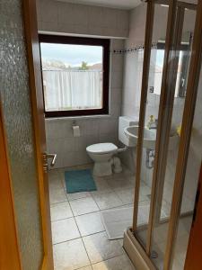 uma pequena casa de banho com um WC e uma janela em Pit-Stop Allgäu em Argenbühl