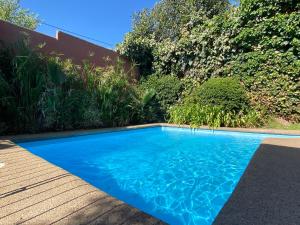 a swimming pool with blue water in a yard at Terraza propia y baño privado in Santiago