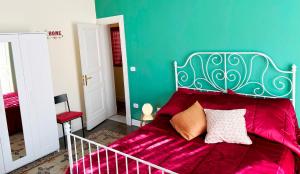 a bedroom with a bed with pink sheets and a green wall at Medinat House in Catania