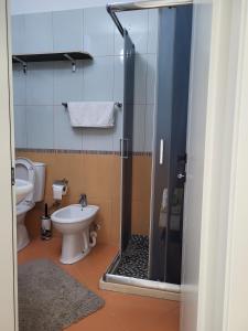 a bathroom with a toilet and a glass shower at Alex's Apartment 2 in Durrës +11 photos