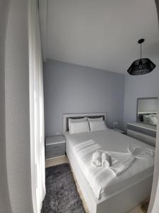 a bedroom with a white bed with two pillows at Alex's Apartment 2 in Durrës