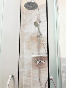 a shower with a shower head in a bathroom at Medinat House in Catania