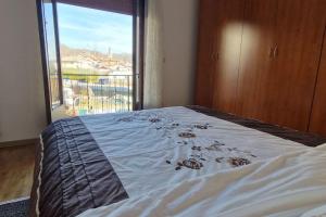 un letto in una camera con una grande finestra di Appartamento Pedavena a Pedavena