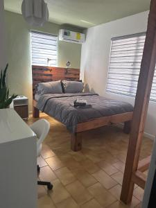 1 dormitorio con 1 cama y 1 silla en Moon’s Place en Toa Baja