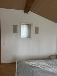a white bedroom with a bed and a window at Relax Apartment in Krumbach
