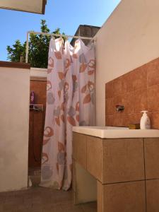 La salle de bains est pourvue d'un rideau de douche et d'un lavabo. dans l'établissement Casa Vacanze Mareblù, à Alliste