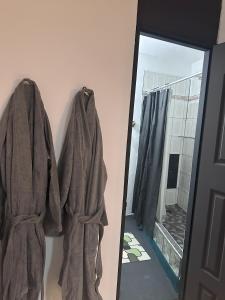 a mirror next to a robe hanging on a wall at Moon’s Place in Toa Baja