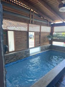 a swimming pool in a house with a wooden wall at Moon’s Place in Toa Baja