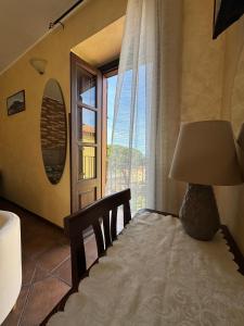 a bedroom with a bed with a lamp and a window at B&B Rivellini in Tropea