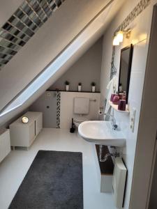 an attic bathroom with a sink and a staircase at Ferienwohnung Obereickum in Herford