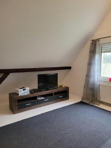 a living room with a flat screen tv on a shelf at Ferienwohnung Obereickum in Herford