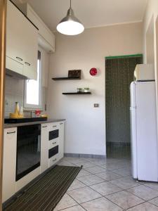 Il comprend une cuisine équipée d'un réfrigérateur blanc. dans l'établissement Casa Vacanze Mareblù, à Alliste
