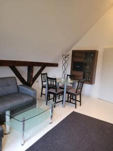 un soggiorno con divano, tavolo e sedie di Ferienwohnung Obereickum a Herford