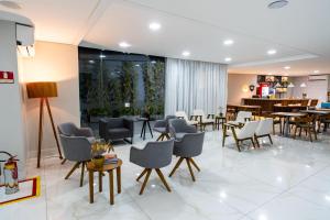 a lobby with chairs and tables and a restaurant at Stop Way Hotel Fortaleza in Fortaleza