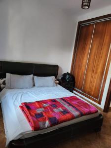 a bedroom with a bed with a colorful quilt on it at Appartement Cassia situé à Cabo Negro in Tétouan