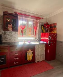 eine Küche mit einem roten Kühlschrank und einem Fenster in der Unterkunft Casetta Valderoa Fiumicino in Fiumicino
