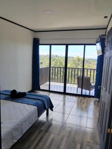 a bedroom with a bed and a view of a balcony at El Paraíso Escondido in San Juan