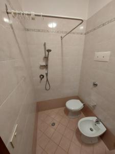 a bathroom with a shower and a toilet and a sink at Flavia Flats in Bibione +32 photos