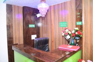 ムンバイにあるAirport Cabin Stay Mumbai Near T2の花瓶を用意したフロントデスク