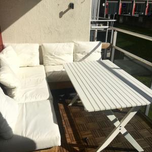 a white bench sitting on top of a balcony at Trivelig leilighet i Kristiansand sentrum! in Kristiansand