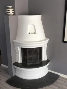 a white fireplace with a lamp on top of it at Trivelig leilighet i Kristiansand sentrum! in Kristiansand