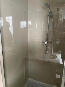 um chuveiro com uma porta de vidro na casa de banho em Maison indépendante 7 minutes RER B em Antony