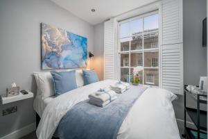 a bedroom with a large bed with towels on it at Luxury 5 bedroom house in Star Street in London