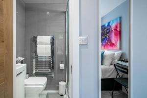 uma casa de banho com um WC branco e um lavatório. em Luxury 5 bedroom house in Star Street em Londres