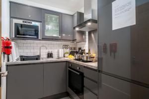 uma cozinha com um lavatório e um fogão em Luxury 5 bedroom house in Star Street em Londres