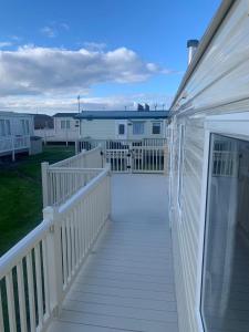 une promenade menant à une terrasse couverte d'une maison dans l'établissement A14 is a 3 bedroom caravan on Whitehouse Leisure park with large decking, à Abergele