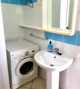 a bathroom with a washing machine and a sink at Residencial Ilha do Fogo app 205 in Santa Maria