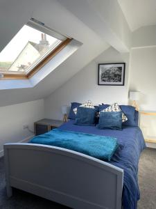 een slaapkamer met een blauw bed op een zolder bij The Hayloft, Marsden in Huddersfield