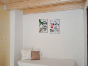 a white couch in a room with two pictures on the wall at Salento Rooms in Leverano