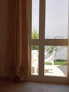 an open door to a patio with a white chair outside at Salento Rooms in Leverano