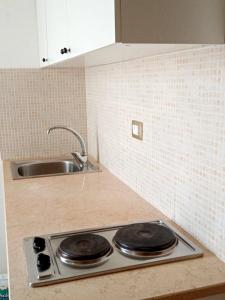 a kitchen counter with a sink and a stove at Salento Rooms in Leverano